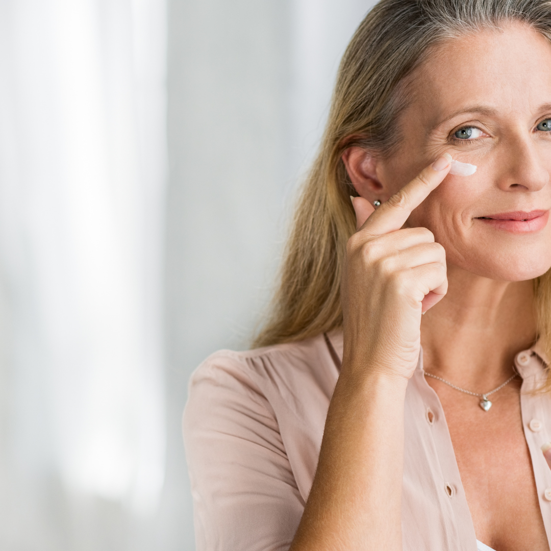 Femme souriante appliquant une crème contour des yeux pour lisser les ridules et raffermir le regard, dans le cadre du forfait beauté Le Luxe.