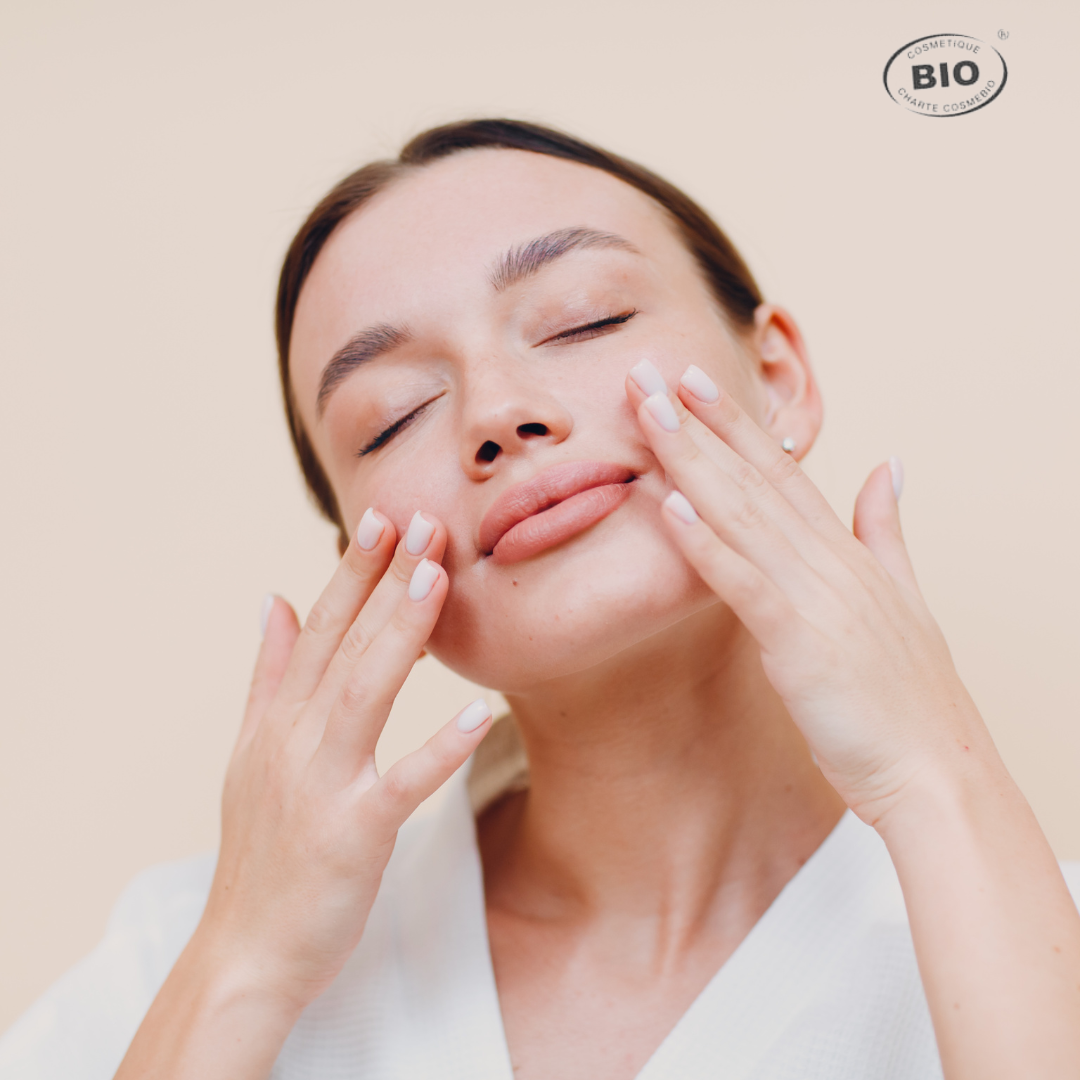 Soin quotidien d'une jeune femme appliquant une crème hydratante bio sur son visage, symbole de douceur et de routine beauté naturelle.