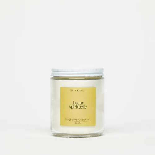 Chandelle Lueur Spirituelle de Selv Rituel dans un pot en verre transparent avec une étiquette jaune minimaliste sur fond blanc.
