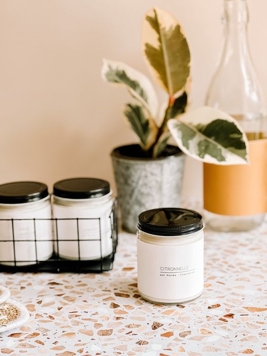 Une chandelle de soya citronnelle, posée sur une table terrazzo, idéale pour une ambiance fraîche et naturelle.