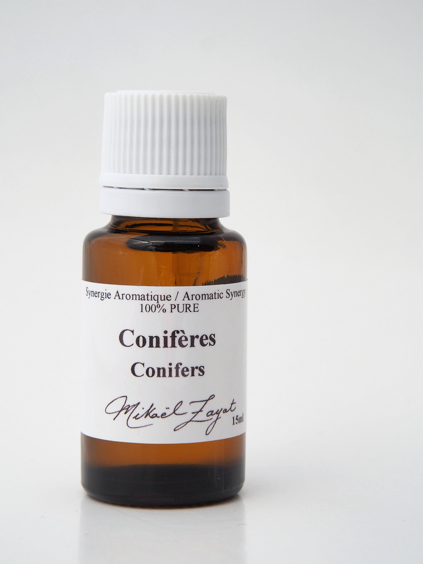 Flacon d’huile essentielle Conifères de Mikaël Zayat, une synergie aromatique 100 % pure aux arômes boisés et résineux évoquant la forêt boréale canadienne, l'air pur.