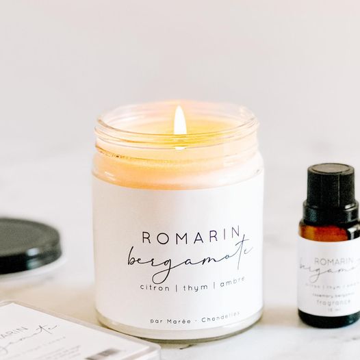 Chandelle de soya Romarin Bergamote allumée, avec des notes de citron, thym et ambre, accompagnée d'une huile essentielle pour une ambiance réconfortante.