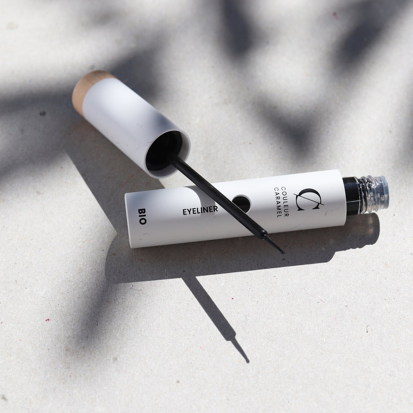 Application d’un eyeliner bio Couleur Caramel posé sur une surface lumineuse, idéal pour souligner ton regard tout en respectant ta peau sensible.