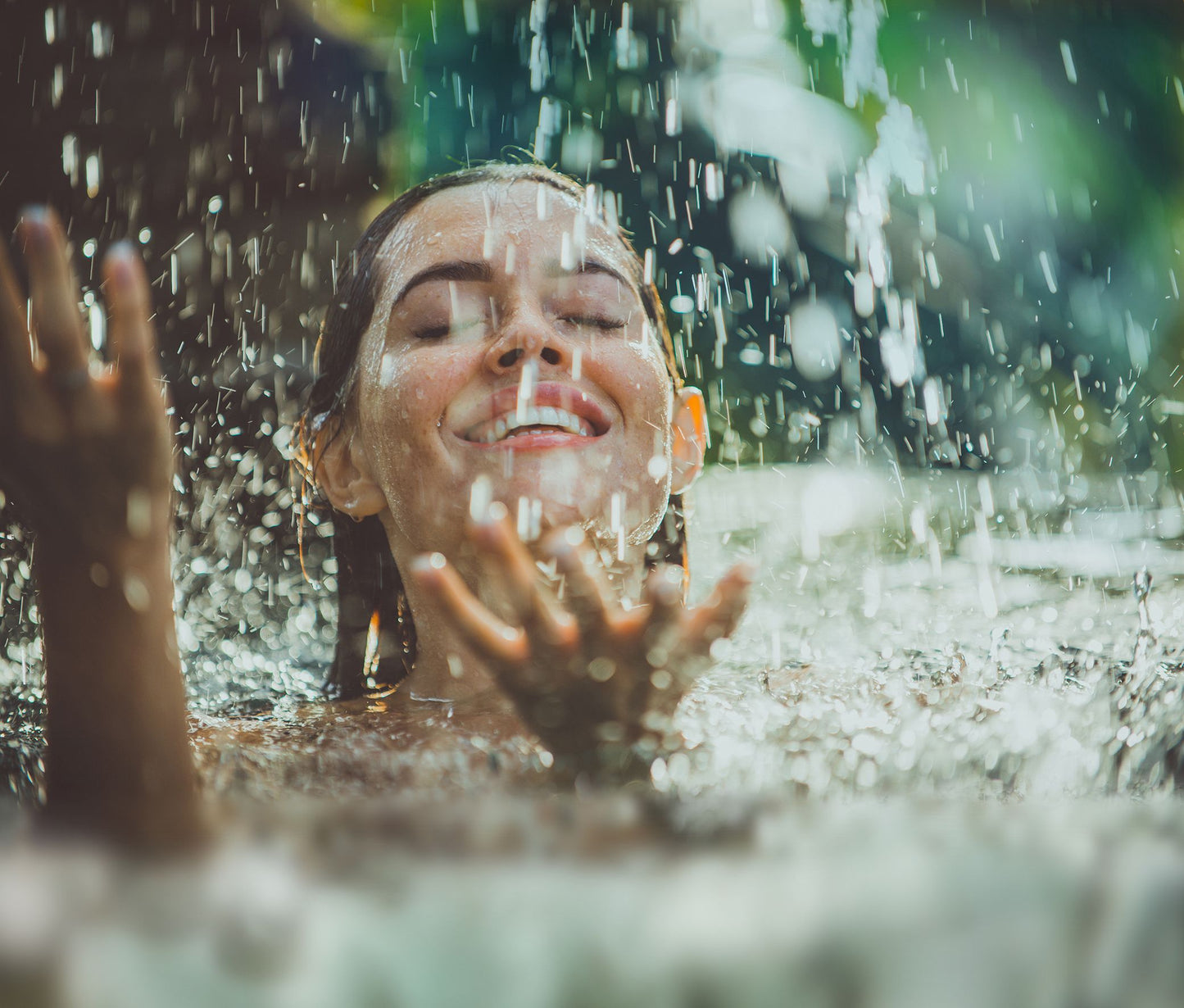 Femme profitant d’une douche rafraîchissante, évoquant la pureté et l’effet apaisant de l’eau thermale naturelle sur la peau.