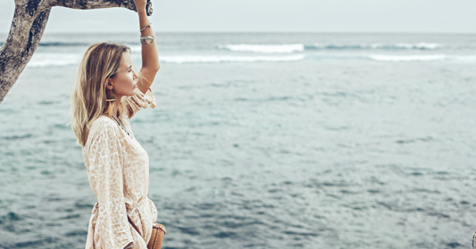 Femme qui est relaxe près de l'océan et qui fait référence a l'hydratation de sa peau
