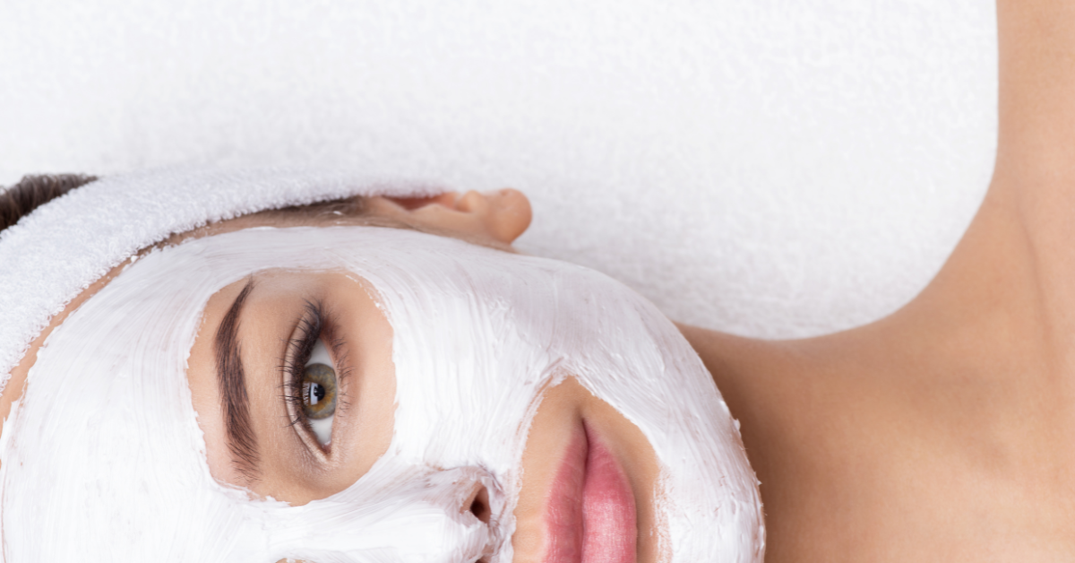 Application du Masque Purifiant Pure de Nelly Devuyst sur le visage d’une femme, soin purifiant à la texture crème blanche qui aide à détoxifier la peau et à retrouver un teint plus net.