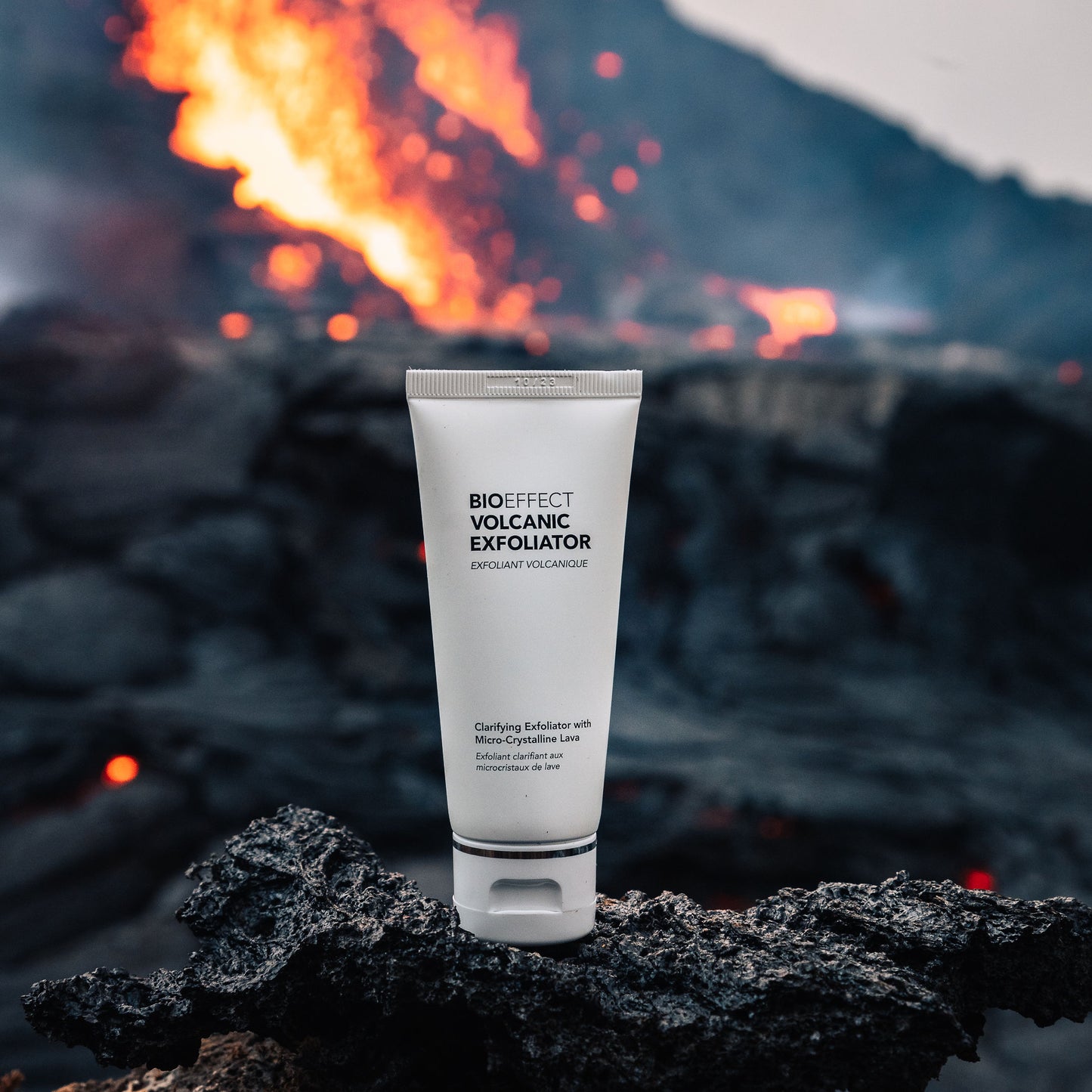 Exfoliant Volcanique Bioeffect pose sur une roche de lave noire devant une eruption volcanique incandescente en Islande. Un soin pur inspiré par la force des elements.