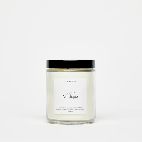 Chandelle en pot de verre avec couvercle noir et étiquette minimaliste blanche, offrant une esthétique épurée et naturelle.