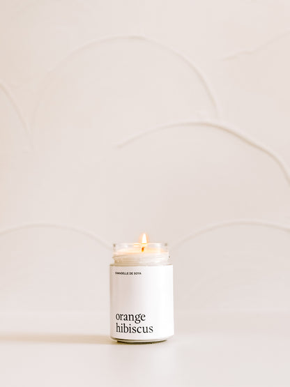 Découvrez l’élégance de 'Orange Hibiscus', une chandelle au design minimaliste qui illumine et parfume subtilement votre quotidien.