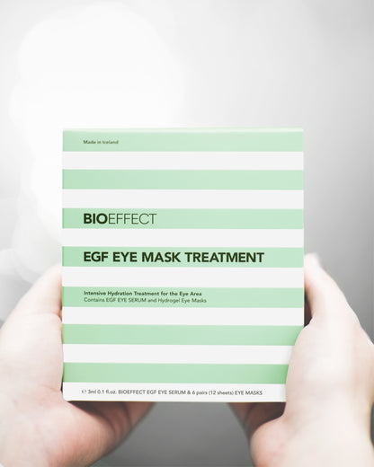 Coffret hydratant EGF Eye Mask Treatment de Bioeffect tenu dans les mains, rayures vert menthe et blanches, fabriqué en Islande pour une hydratation ciblée du contour des yeux.