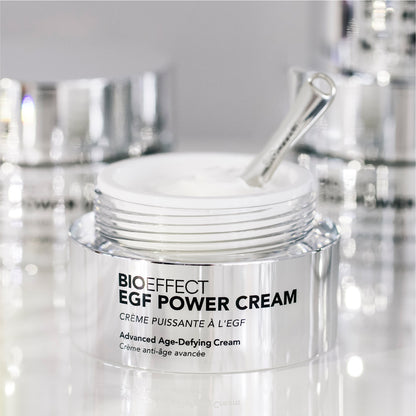 Pot de la EGF Power Cream avec sa spatule posée dans la crème, dans une ambiance éclatante et haut de gamme, refletant le soin anti-âge avancé.
