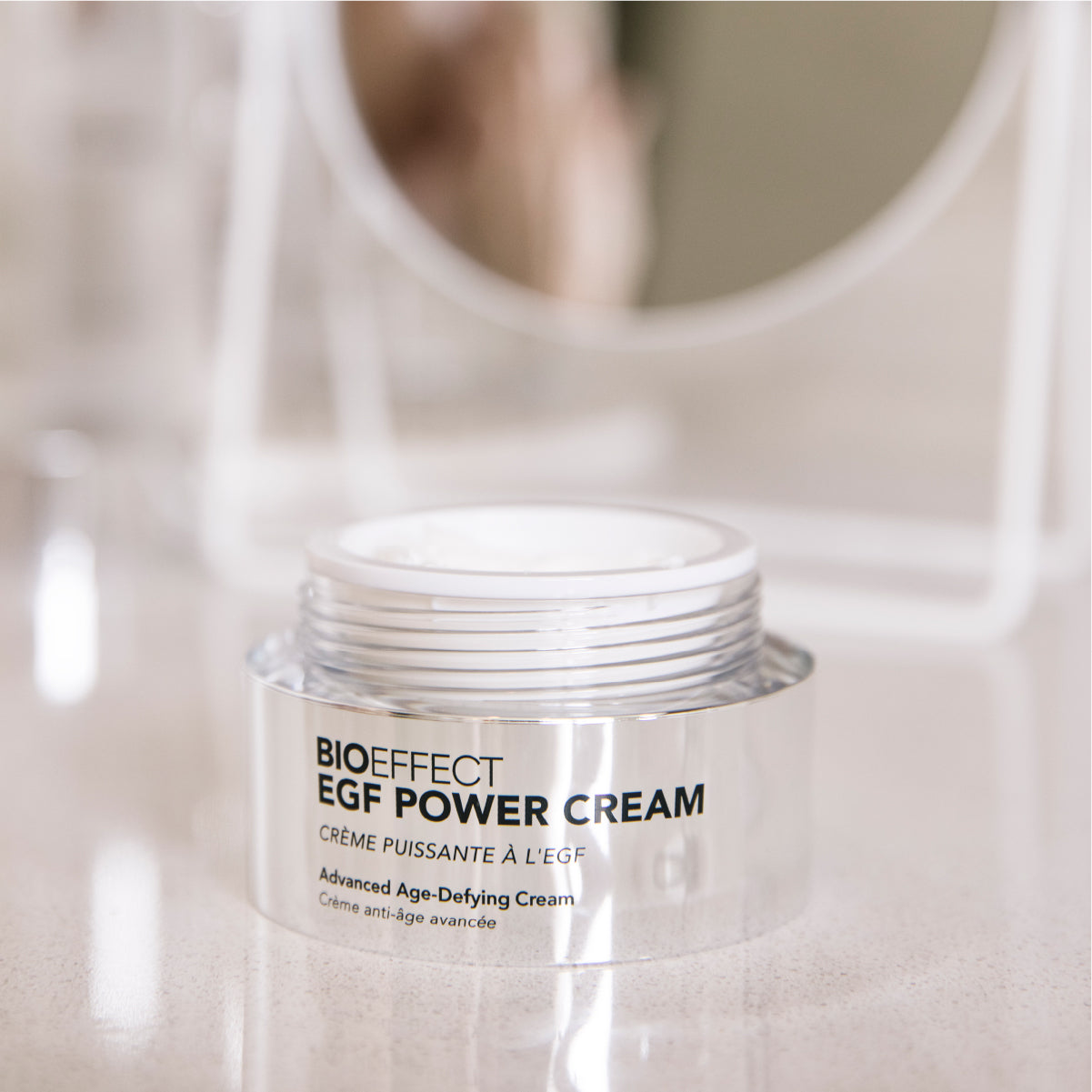 Crème EGF Power Cream de Bioeffect ouverte, posée sur un comptoir de salle de bain, avec un miroir flou à l’arrière et ambiance épurée.