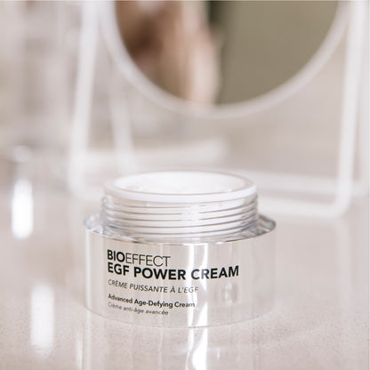 Crème EGF Power Cream de Bioeffect ouverte, posée sur un comptoir de salle de bain, avec un miroir flou à l’arrière et ambiance épurée.