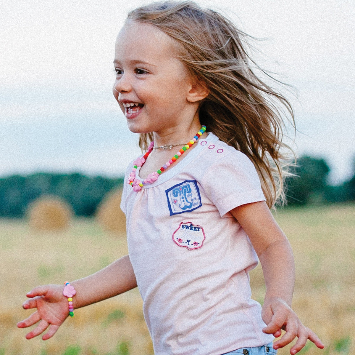 Enfant souriante jouant à l’extérieur, symbole de la protection douce et sécuritaire offerte par la Crème Solaire Minérale BioSolar Nelly DeVuyst, idéale pour les peaux sensibles et délicates.