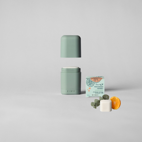 Application d’un déodorant rechargeable Kiima vert accompagné d’une recharge parfum Mauvaises Herbes, symbole d’une routine naturelle, végane et durable.