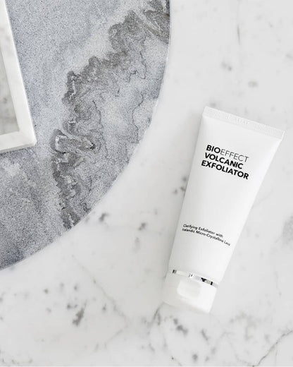 Le Volcanic Exfoliator de Bioeffect repose sur une surface de marbre blanc et de pierre grise, symbolisant purete, clarte et soin raffine de la peau.