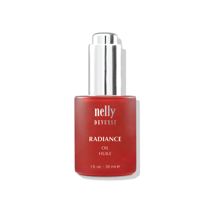 Flacon rouge de l’Huile Radiance Mélatonine Nelly DeVuyst, soin anti-âge éclat formulé à base d’huiles naturelles pour revitaliser et illuminer le teint.
