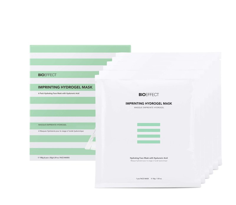 Présentation du coffret Bioeffect Imprinting Hydrogel Mask contenant 6 masques pour le visage, à base d'acide hyaluronique, posés devant une boîte rayée verte et blanche.