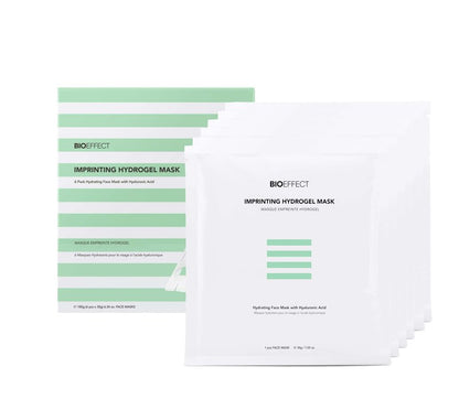 Présentation du coffret Bioeffect Imprinting Hydrogel Mask contenant 6 masques pour le visage, à base d'acide hyaluronique, posés devant une boîte rayée verte et blanche.