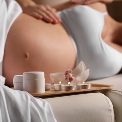 Femme enceinte allongée dans un espace de bien-être, entourée de bougies et de soins, créant un instant apaisant pour elle et son bébé.