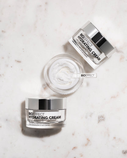 Trois pots de la crème Bioeffect disposés sur une surface en marbre clair, avec vue du dessus sur la texture, renforçant l’élégance et le soin de qualité.