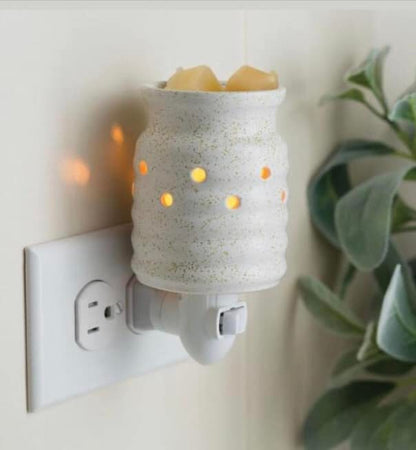 Diffuseur mural pour cubes de cire avec lumière douce intégrée, créant une ambiance chaleureuse et une diffusion continue d’arômes naturels.